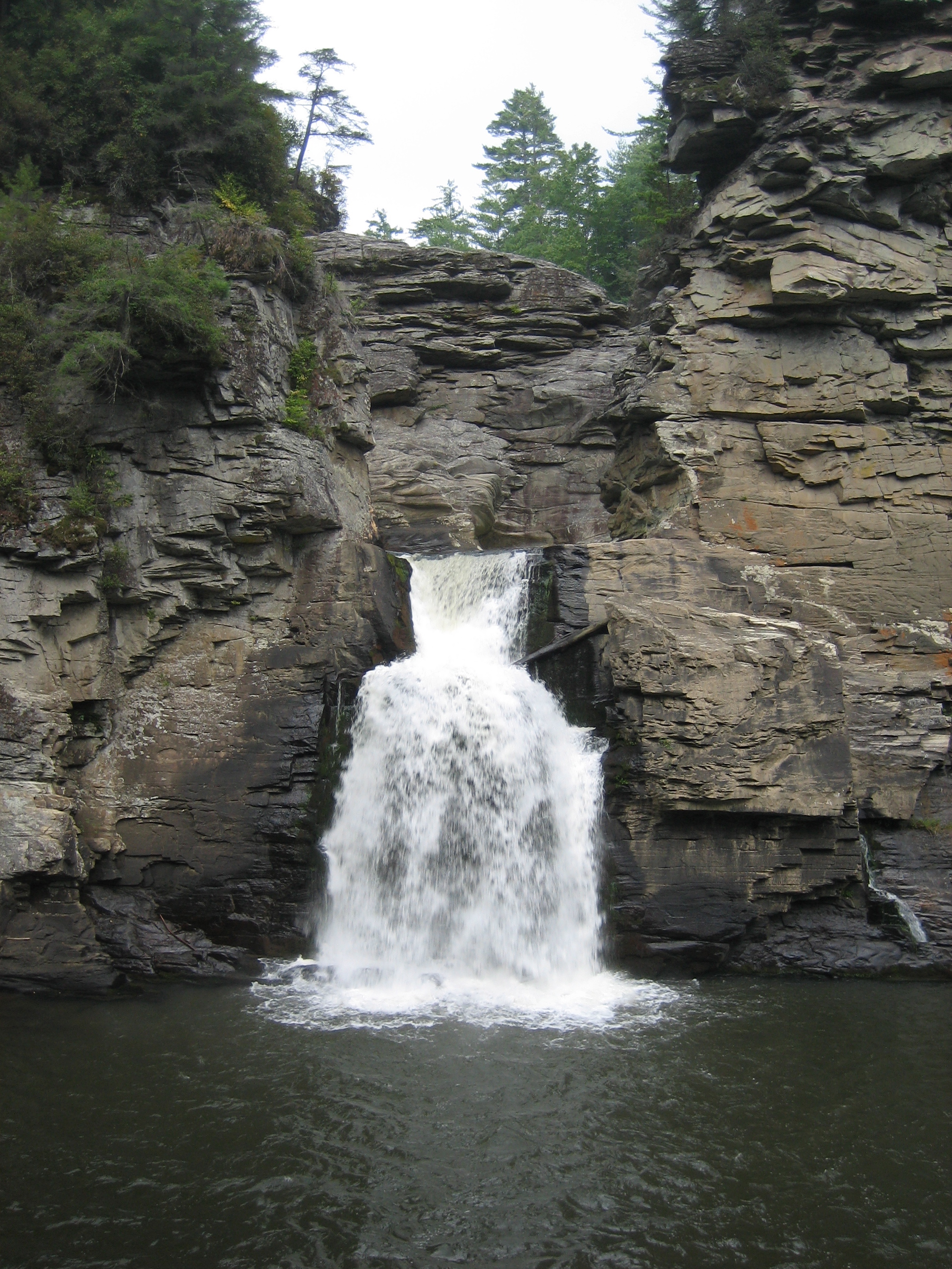 Tall waterfall dropping through a layered-rock gorge in the NC High Country