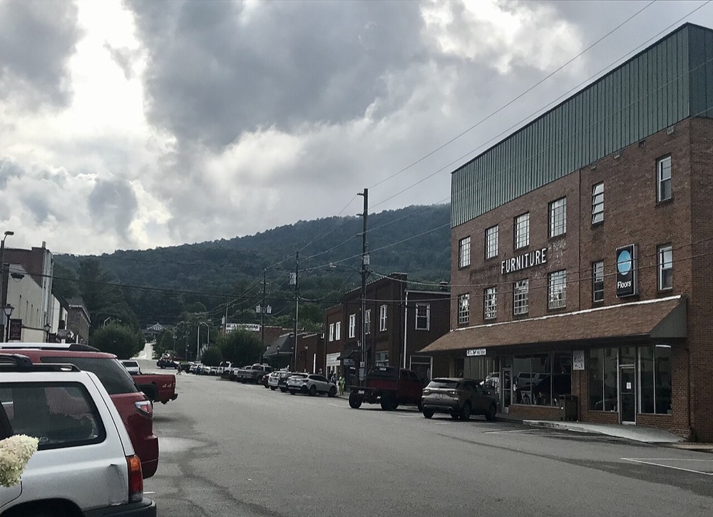 Downtown West Jefferson, North Carolina, with brick storefronts and the mountains in the distance