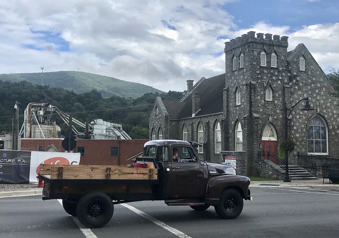 Downtown West Jefferson, North Carolina, with a vintage truck passing the historic stone church